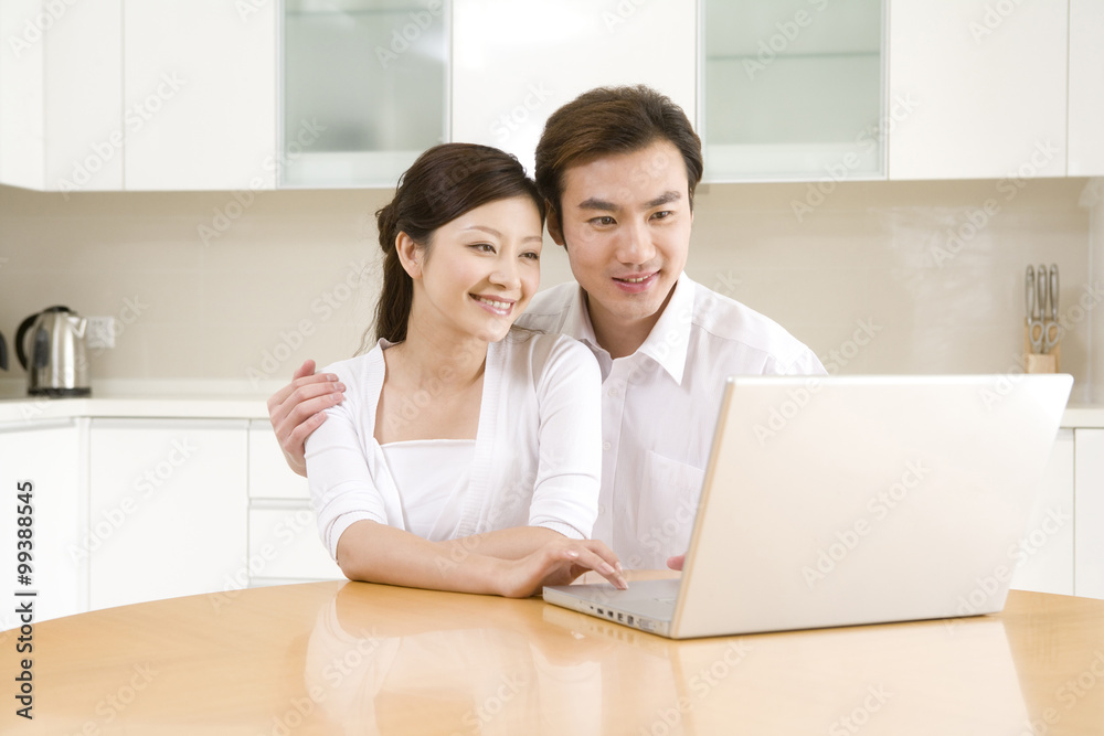 Young couple using a laptop at home Young couple using a laptop at home
