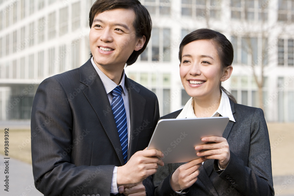 Business partners using a digial tablet together Business partners using a digial tablet together