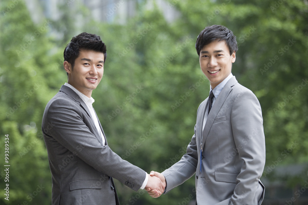 Young business person shaking hands outdoors Young business person shaking hands outdoors