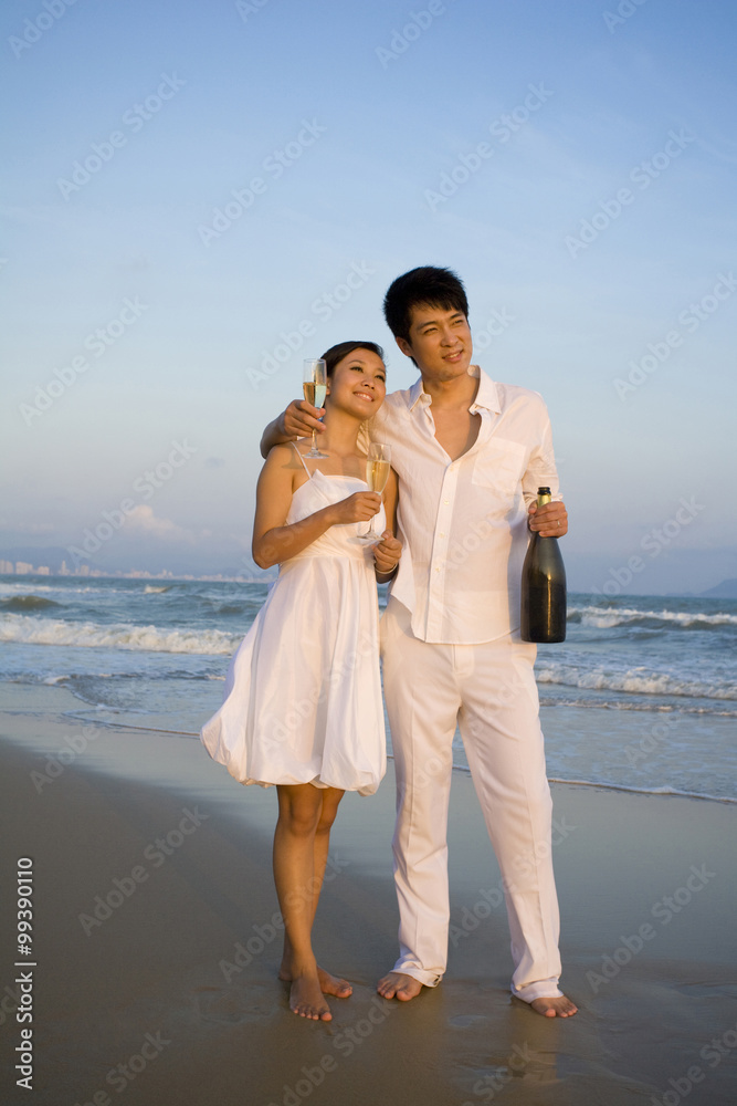 Young couple celebrating with a bottle of champagne