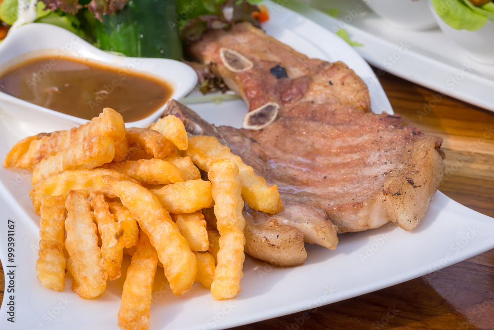 French Fries and Steak Pork Chop with mushroom mustard sauce,salad. French Fries and Steak Pork Chop with mushroom mustard sauce,salad.