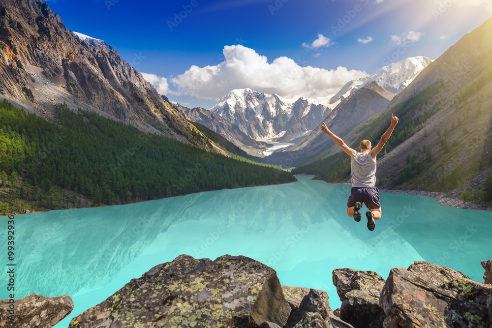 Beautiful mountain landscape with lake and jumping man.  Extreme sports concept. - obrazy, fototapety, plakaty 