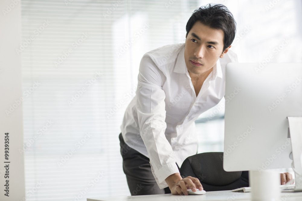 Young businessman using computer in office Young businessman using computer in office