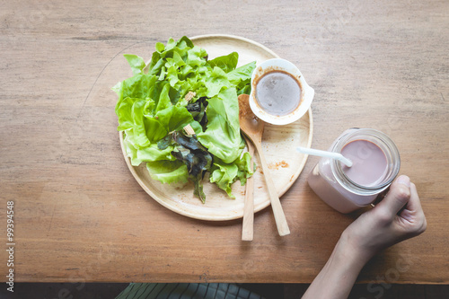 Green delicious salad and a glass of chocolate milk