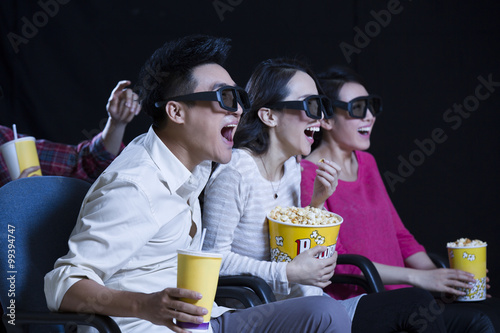 Young couple watching 3D movie in cinema photo