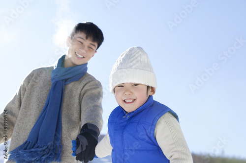 Father playing with son in snow