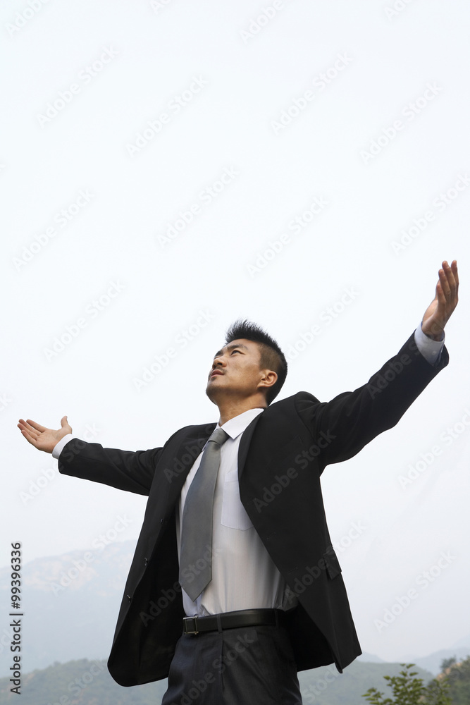 A businessman spreads his arms wide A businessman spreads his arms wide
