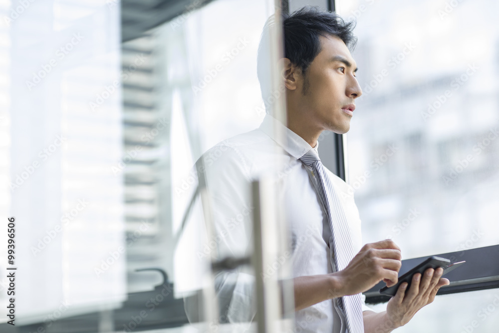 Young businessman using smart phone in office Young businessman using smart phone in office