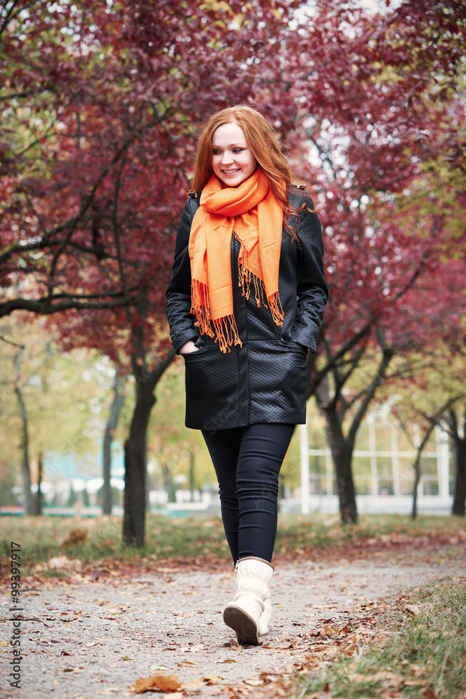redhead girl walk on pathway in city park, fall season redhead girl walk on pathway in city park, fall season