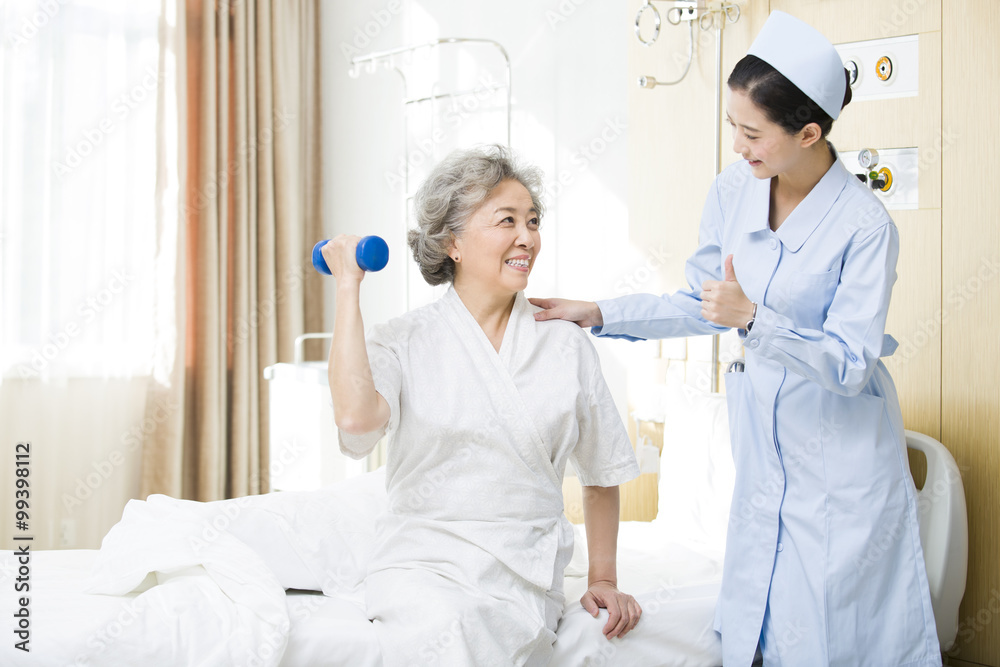 Fototapeta premium Nurse helping senior woman doing rehabilitation training