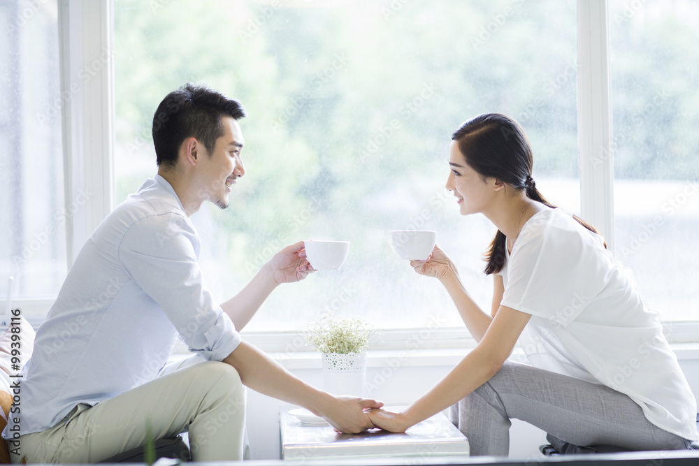 Happy young couple drinking coffee in coffee shop Happy young couple drinking coffee in coffee shop