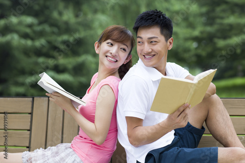 Young couple reading books in park