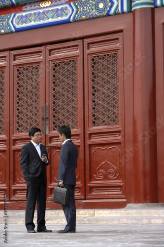 Two Businessmen Talking In The Doorway Of The Forbidden City In Beijing