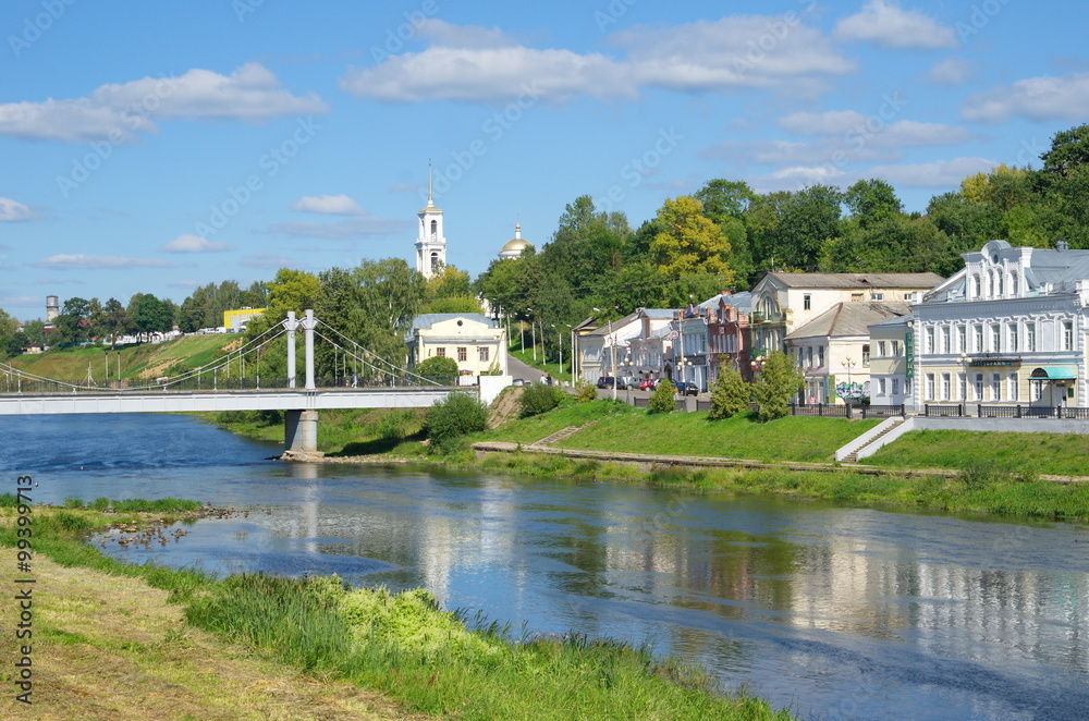 Fototapeta premium TORZHOK, TVER REGION, RUSSIA - AUGUST 19, 2015: View of the pedestrian bridge, the river Tvertsa embankment