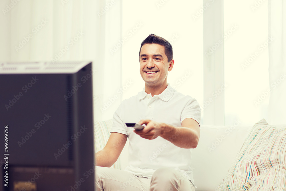 smiling man with remote control watching tv smiling man with remote control watching tv