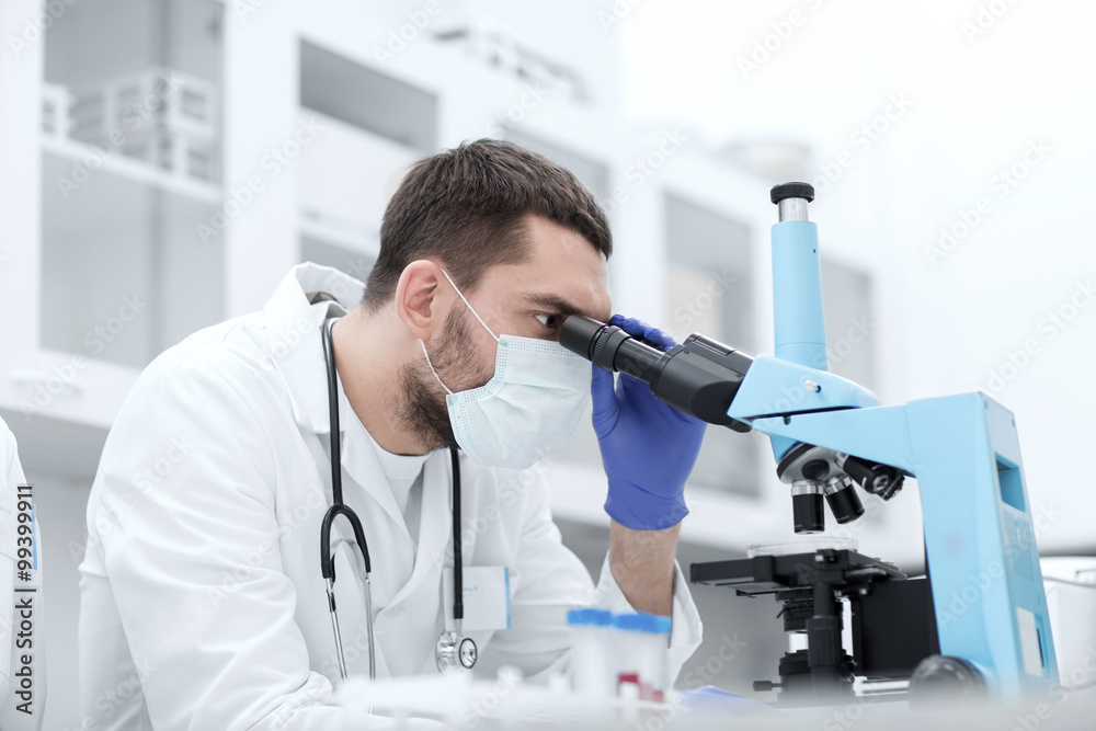 young scientist looking to microscope in lab young scientist looking to microscope in lab