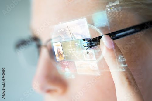 close up of woman in glasses with virtual screen photo