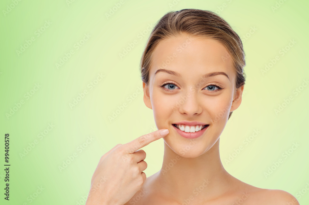 happy young woman pointing finger to her teeth happy young woman pointing finger to her teeth