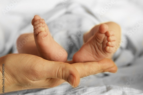 just born baby feet in mother arms while sleeping photo