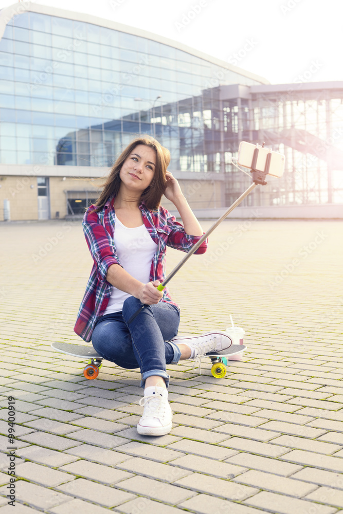 Skateboarder girl making selfie with a stick Skateboarder girl making selfie with a stick