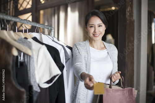 Mature woman with credit card in clothing store © Blue Jean Images