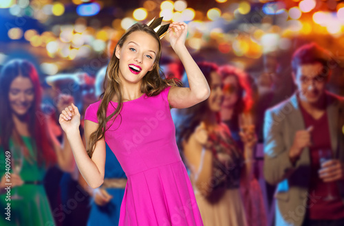 happy young woman in princess crown at night club