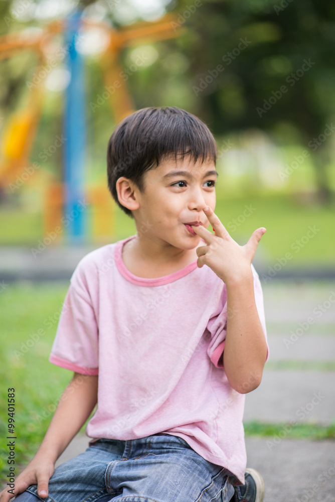 Little boy smiling in the park in summer time Little boy smiling in the park in summer time