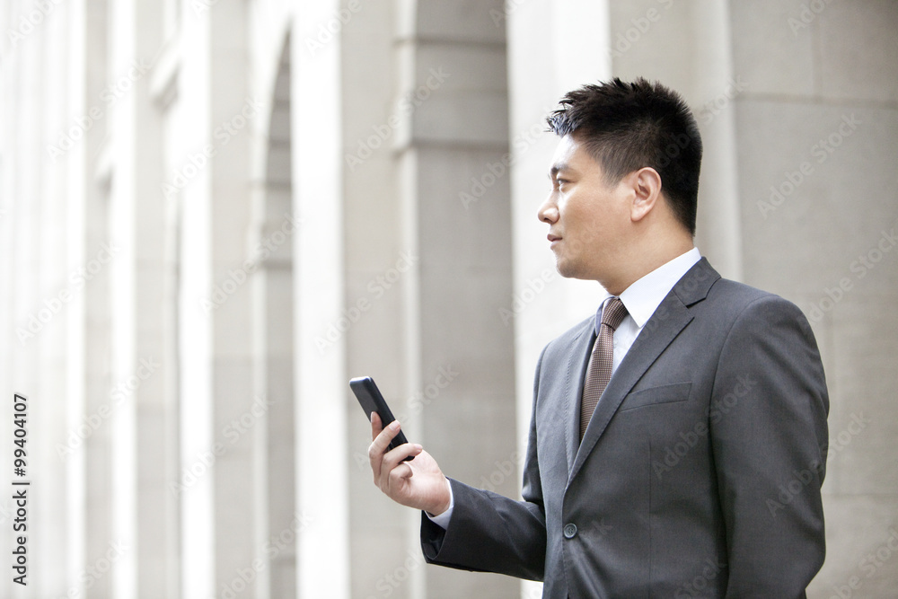 Happy mature businessman with a smart phone outdoors, Hong Kong Happy mature businessman with a smart phone outdoors, Hong Kong