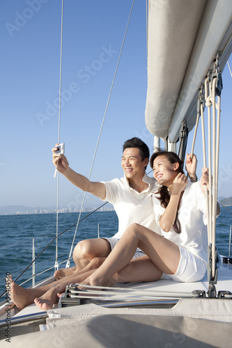 Happy couple taking self portrait on the boat deck