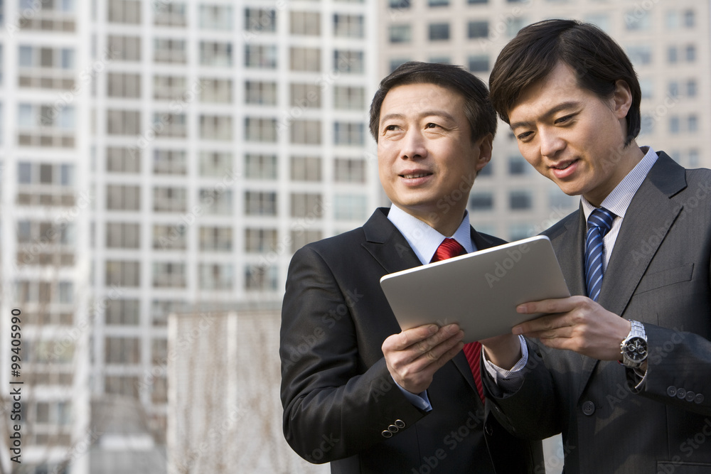 Business partners using a tablet together Business partners using a tablet together