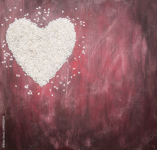 rice for risotto, lined heart, valentines day on wooden rustic background top view close up border,with text area