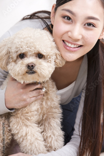 Young woman playing with a pet toy poodle