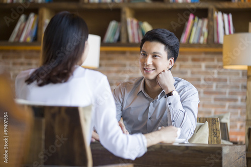 Young woman and man talking in cafe photo