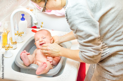 babies crying while mother bathes in bathroom sink basin - newbo photo