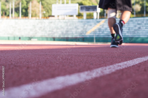 Blurry focus image of the man jogging in running track during knee pain