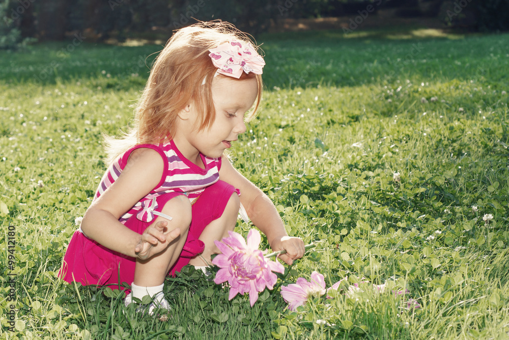 Girl with red hair playing with flowers in nature Girl with red hair playing with flowers in nature