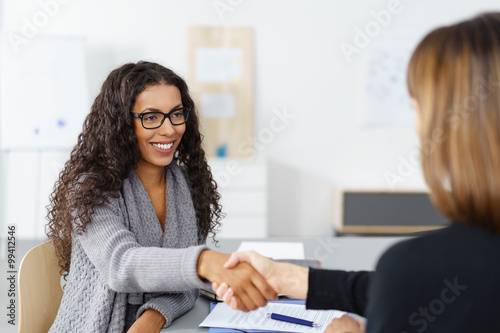 Photos zwei frauen in einer besprechung geben sich die hand zur begrüßung
