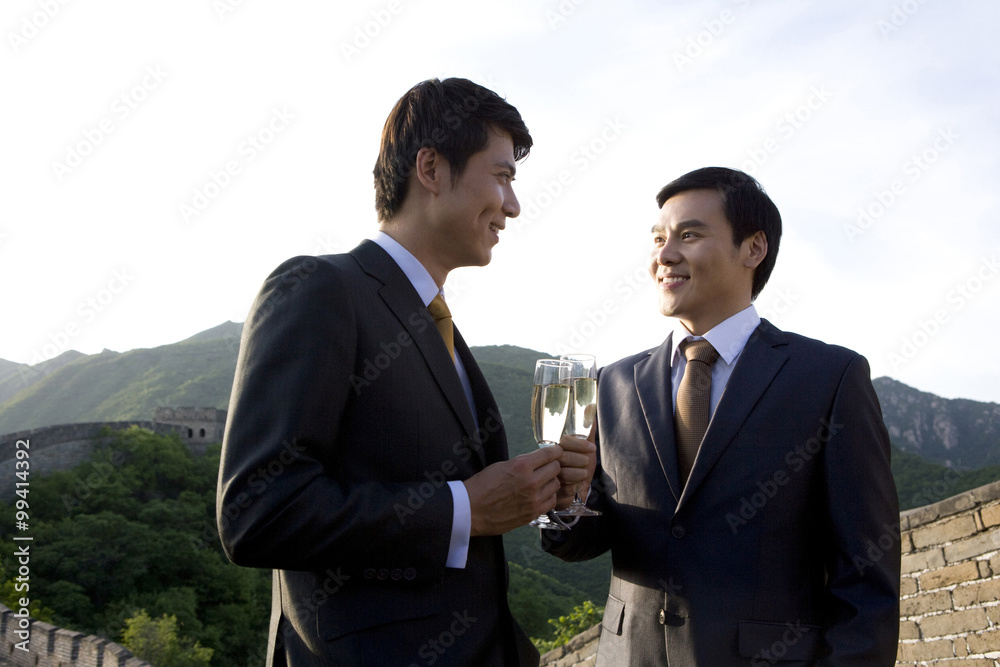 Businessmen having champagne on the Great Wall Businessmen having champagne on the Great Wall