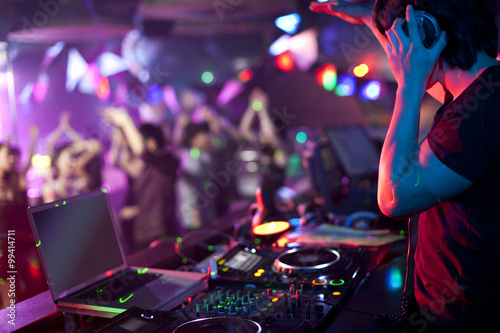 DJ doing record Scratching in nightclub photo