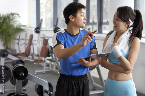 Fototapeta Naklejka Na Ścianę i Meble -  Young Man Instructing Woman At The Gym