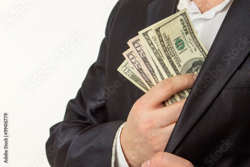 Businessman putting money in suit jacket pocket