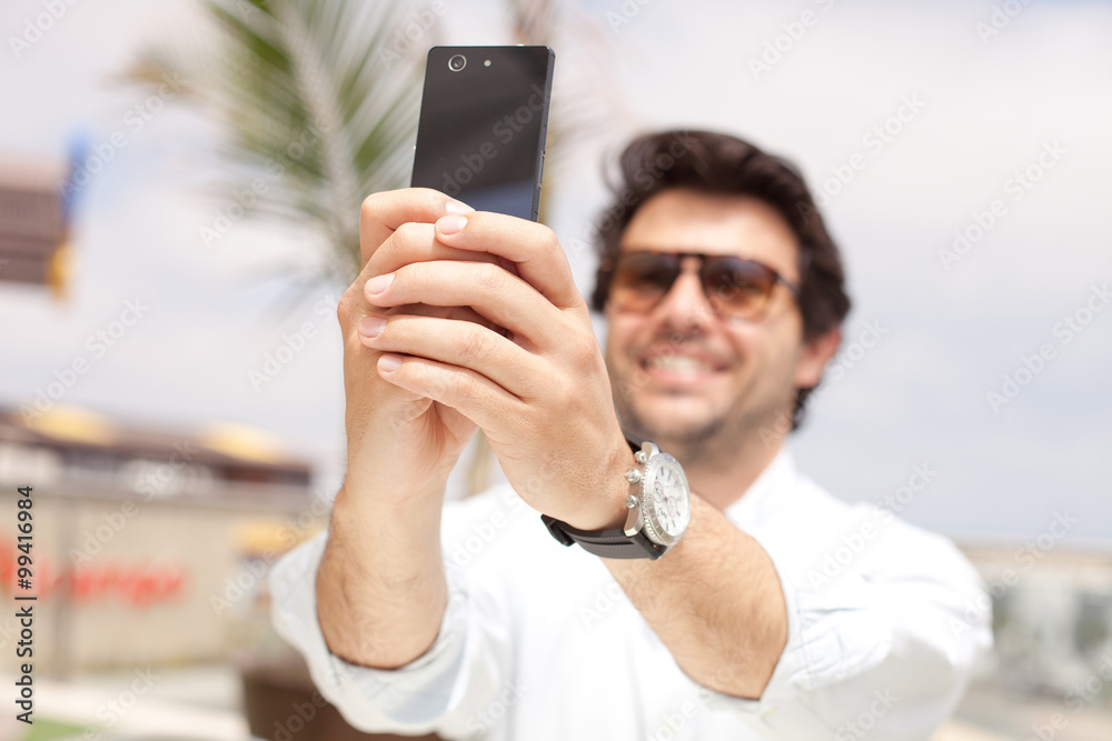 Young man taking a photo with a mobile phone Young man taking a photo with a mobile phone