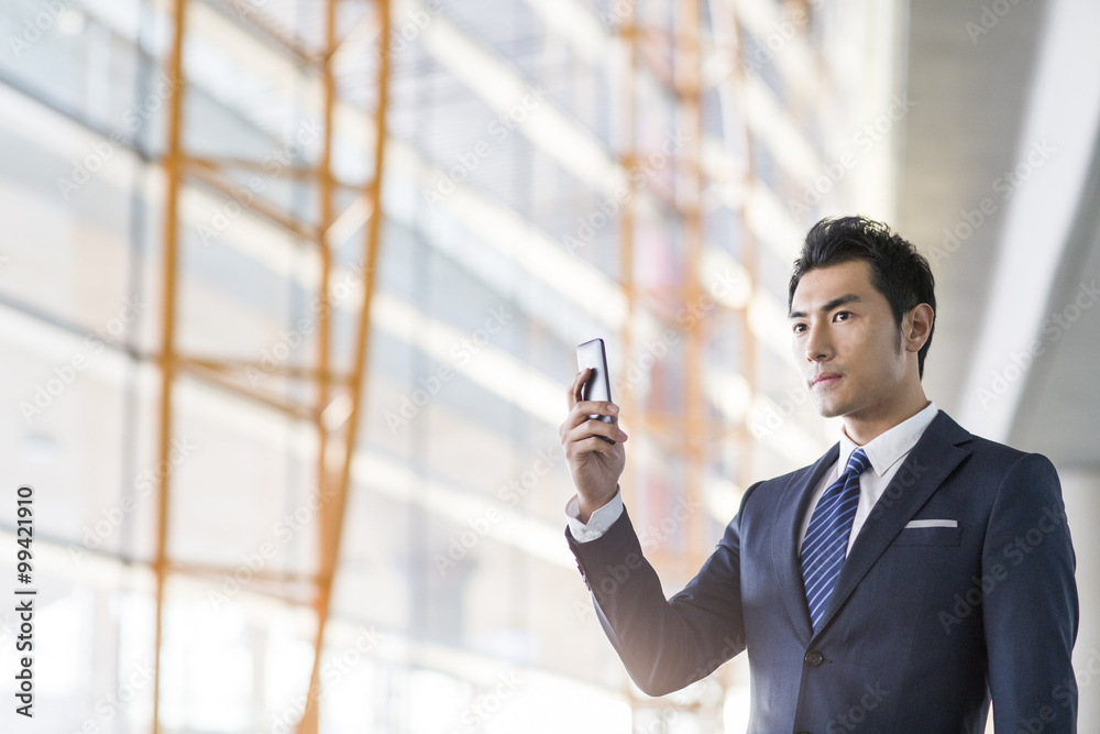 Young businessman using smart phone in airport Young businessman using smart phone in airport