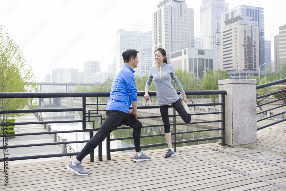 Happy mature couple exercising in park
