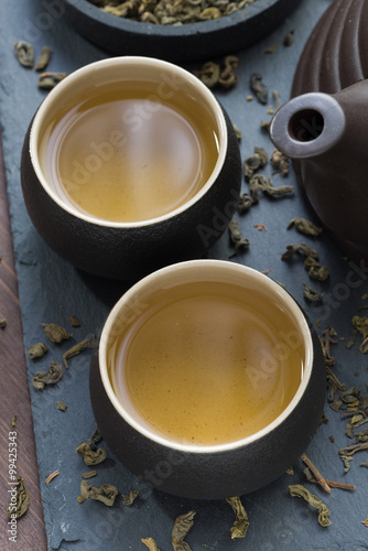 teapot and cups with green tea, top view