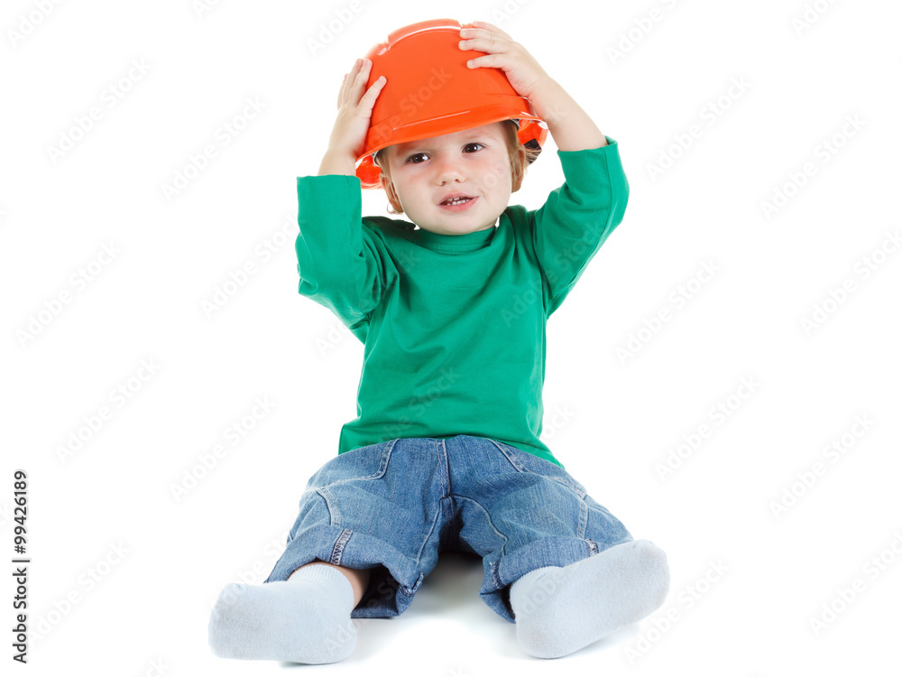 Little child plays with orange construction protective helmet on white background. Little child plays with orange construction protective helmet on white background.