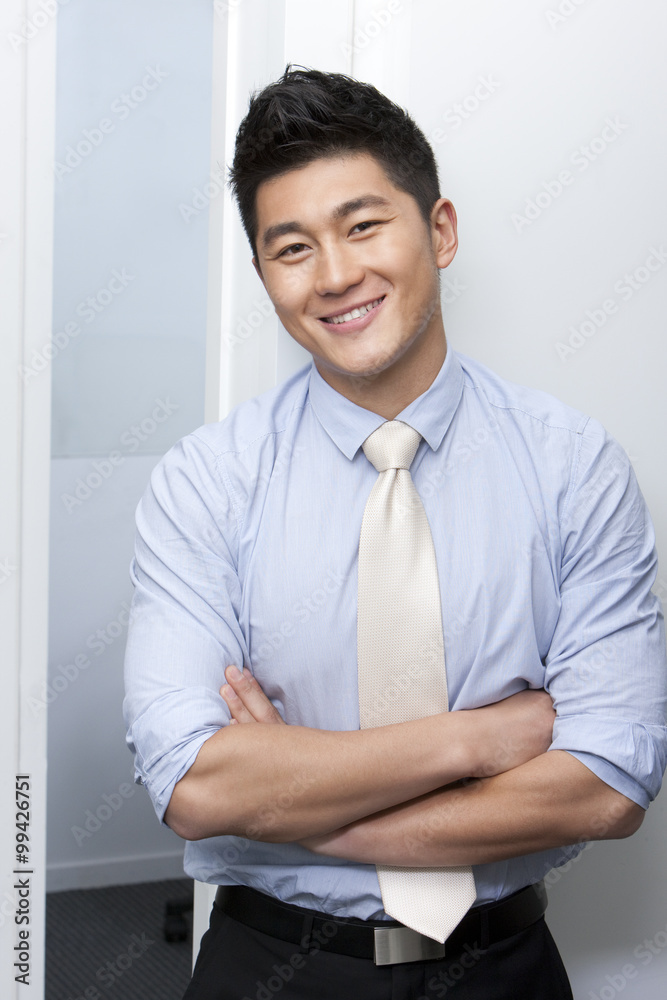 Smiling businessman standing with his arms crossed