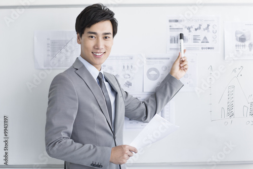 Young businessman pointing the whiteboard in office