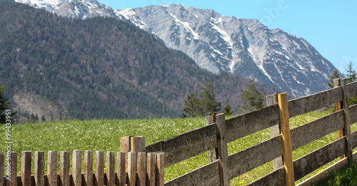 Ein Holzzaun in den Alpen - im Hintergrund ein imposantes Bergmassiv