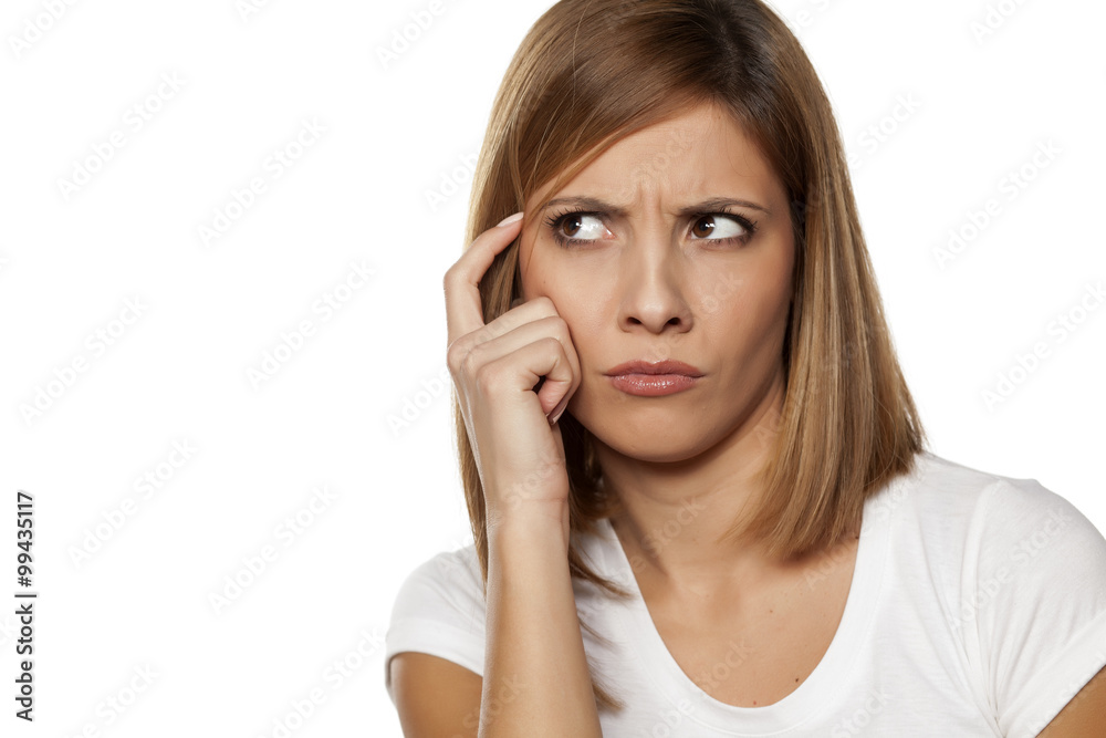frowning young woman thinking on white background frowning young woman thinking on white background